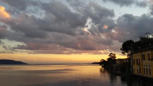 a view of a body of water at sunset at Hotel Garnì Bartabel in Gargnano