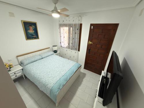 a bedroom with a bed and a ceiling fan at Flamingo Apartman in Torrevieja