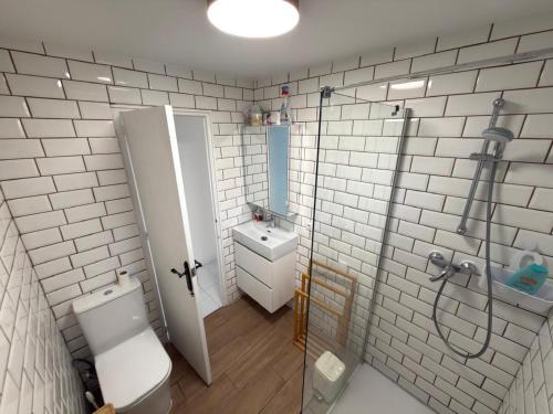a bathroom with a shower and a toilet and a sink at Flamingo Apartman in Torrevieja