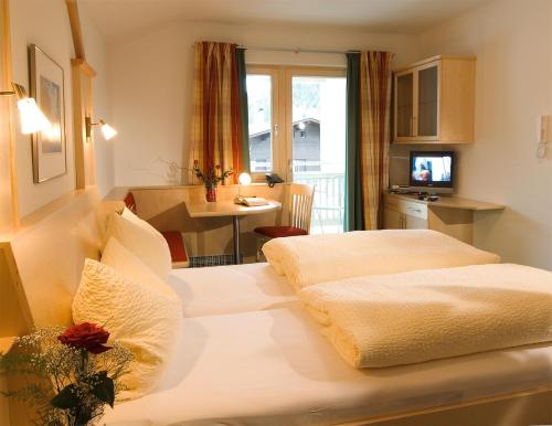 a hotel room with two beds and a kitchen at Appartements Bergsonne in Westendorf
