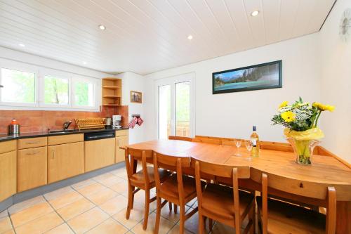a large kitchen with a wooden table and chairs at BaseCamp Apartments in Zermatt