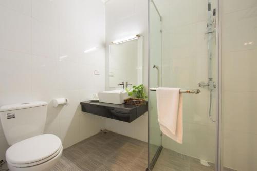 a bathroom with a toilet and a sink and a shower at Hanoi Spoon Boutique Hotel in Hanoi