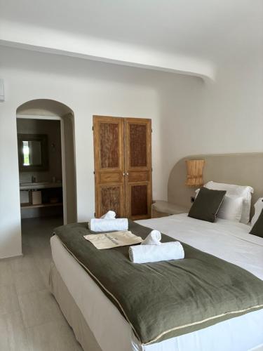 a bedroom with two beds with towels on them at Hôtel Palombaggia in Porto-Vecchio