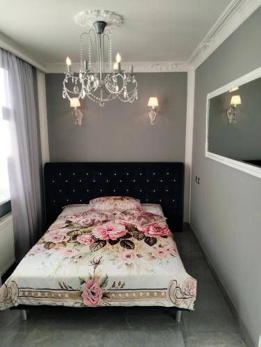 a bedroom with a bed with pink flowers on it at Apartment Sonata in Jūrmala