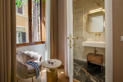 a bathroom with a chair and a sink and a mirror at Hotel Forte in Rome