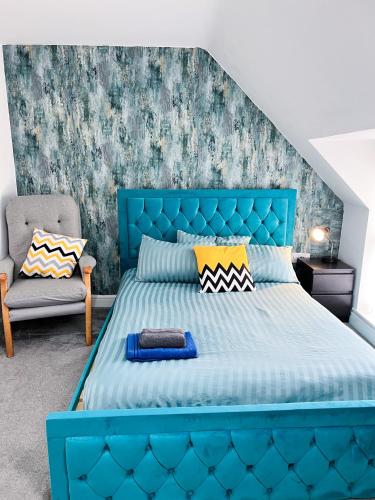 a blue bed with a blue headboard in a bedroom at Luxury Townhouse In Derby City Centre in Derby