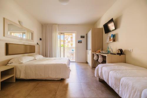 a hotel room with two beds and a kitchen at Crystal Camere in Marcelli