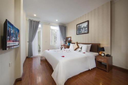 a large white bed in a hotel room at Hanoi Spoon Boutique Hotel in Hanoi