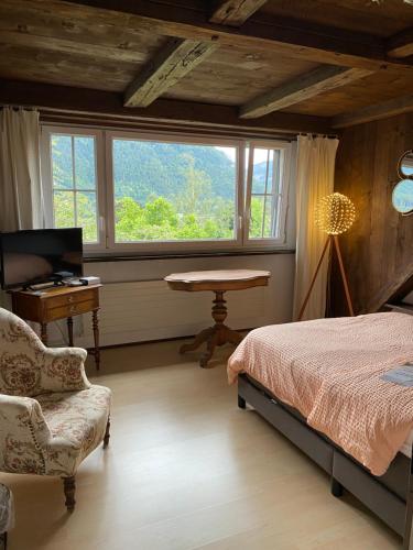 a bedroom with a bed and a desk and a window at La maison du petit bonheur in Moutier