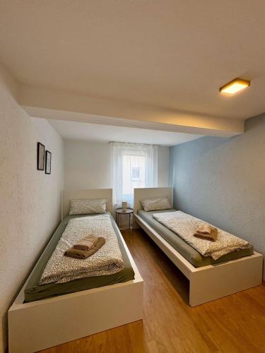 two twin beds in a room with a window at geräumiges Monteurapartment 2 in Bensheim mit Parkplatz in Bensheim