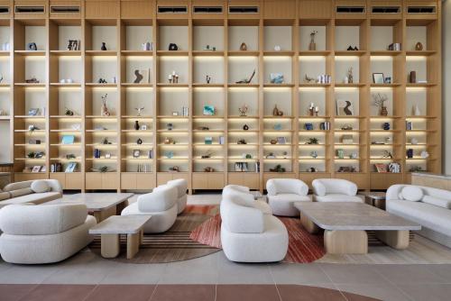 a room with couches and tables and shelves with vases at Fukuoka Prince Hotel Momochihama in Fukuoka
