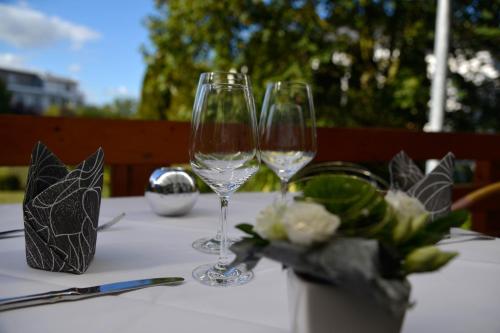 dois copos de vinho sentados numa mesa com flores em Trollinger Hof em Bad Oeynhausen