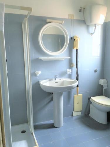 a bathroom with a sink and a mirror and a toilet at Hotel Don Pedro in Portoscuso