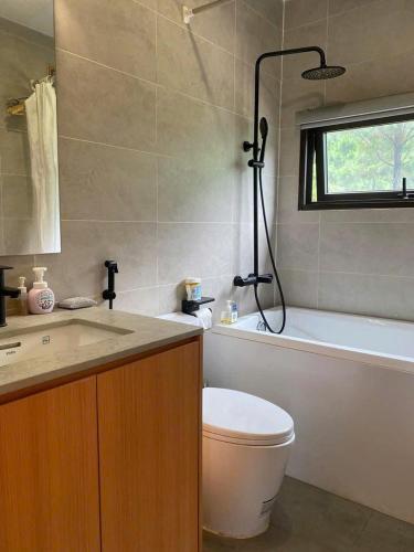 a bathroom with a toilet and a tub and a sink at Pine Hill Villa 3 Vì in Ba Vì