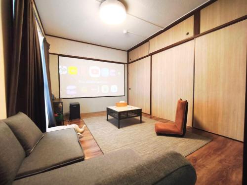 a living room with a couch and a table at Route99 Yumoto 箱根湯本駅近山沿い川沿い 箱根湯本徒歩8分WIFI 大人気ゲーム機無料 最大6名 無料駐車場 in Hakone
