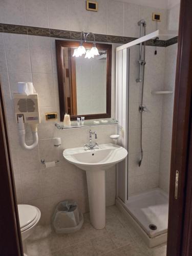 a bathroom with a sink and a shower and a toilet at Hotel Ristorante Rinelli in Margherita di Savoia