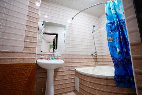 a bathroom with a sink and a tub and a toilet and a sink at RAY Boutique Hotel withTerrace in Bukhara