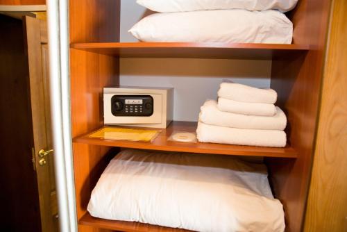 a closet with towels and a clock on a shelf at Gluhoman in Poltava