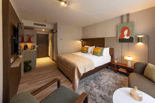 een hotelkamer met een bed en een woonkamer bij Hotel De Bilderberg in Oosterbeek