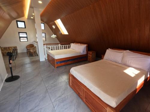 a bedroom with two beds and a balcony at Annie's Lodge Agoo in Agoo