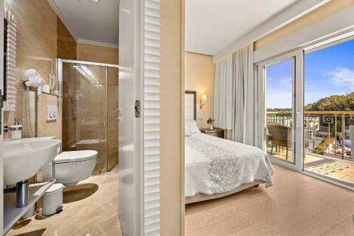 a bedroom with a bed and a bathroom with a balcony at Boutique Hotel Oasi in Pula