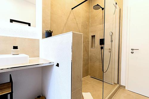eine Dusche mit Glastür im Badezimmer in der Unterkunft LaMiaCasa City 145 qm 2 Baths Parking in Stuttgart