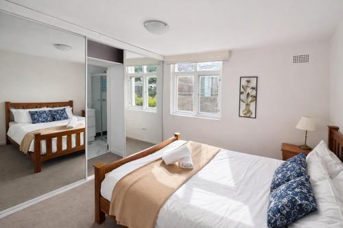 a bedroom with a bed and a mirror at Sydney Harbour Side Waterfront Apartment in Sydney