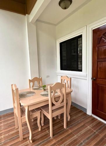 a dining room with a table and chairs and a window at Nielo's Apartment Door 4 in Dapitan