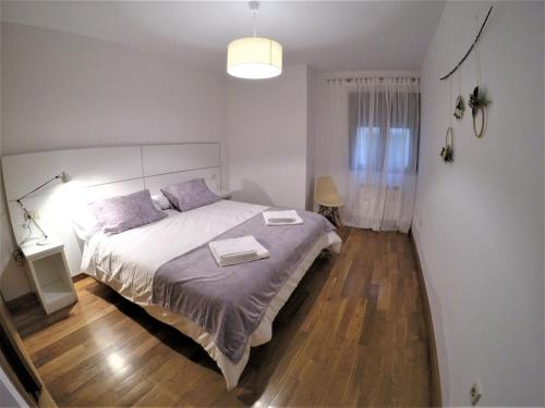 a bedroom with a large bed with two towels on it at El Balcón de la Encina in Ponferrada