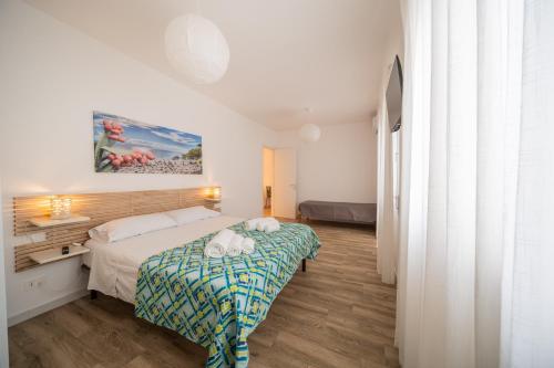 a bedroom with a bed with a green and blue blanket at La Dimora del Sole in Monopoli