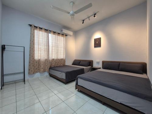 a bedroom with two beds and a ceiling fan at Lim'S Homestay Kudat in Kudat