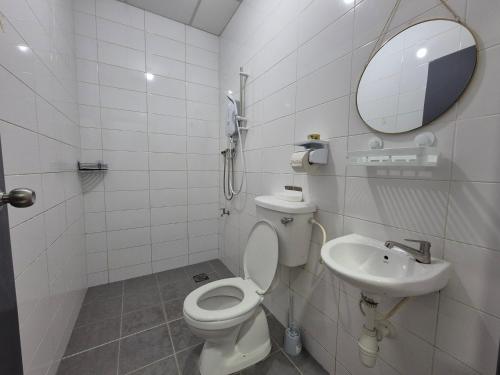 a white bathroom with a toilet and a sink at Lim'S Homestay Kudat in Kudat
