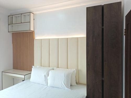 a bedroom with a bed with white sheets and a cabinet at Kbazz apartments in Ibadan