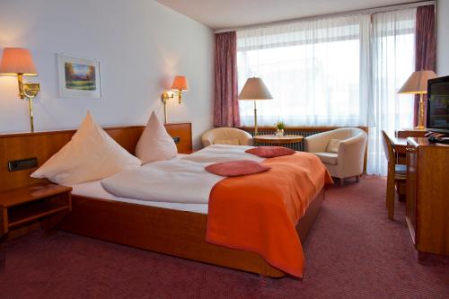 ein Hotelzimmer mit einem großen Bett und einem Fernseher in der Unterkunft Hotel Buck in Bad Urach