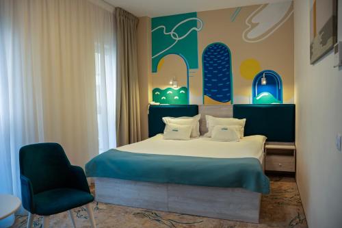 a hotel room with a bed and a chair at Fiald Hotel & Spa in Bacău