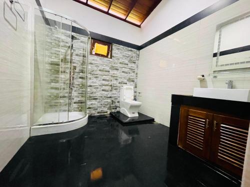 a bathroom with a glass shower and a toilet at Dream villa in Imaduwa