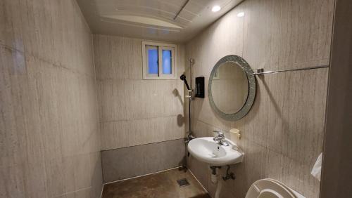a bathroom with a sink and a mirror at Jin Stay Hotel in Changwon