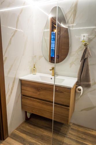 a bathroom with a sink and a mirror at Sky Apartman 2 in Kučevo