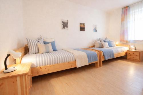 a bedroom with two beds with blue and white pillows at Boje 5 in Schillig