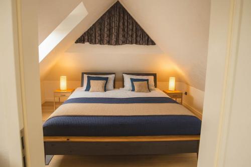 a bedroom with a bed with blue pillows at Boje 21 in Schillig