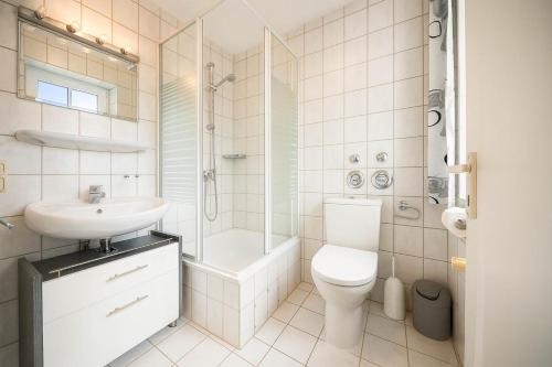 a bathroom with a toilet and a sink and a shower at Boje 21 in Schillig