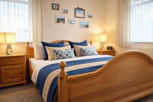 a bedroom with a large wooden bed with blue pillows at Boje 7 in Schillig