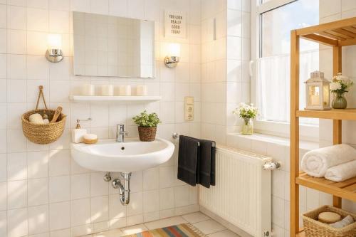 a white bathroom with a sink and a mirror at Boje 7 in Schillig