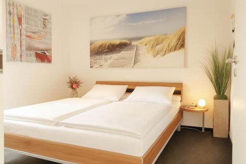 ein Bett in einem Zimmer mit zwei weißen Kissen in der Unterkunft Granata in Schillig