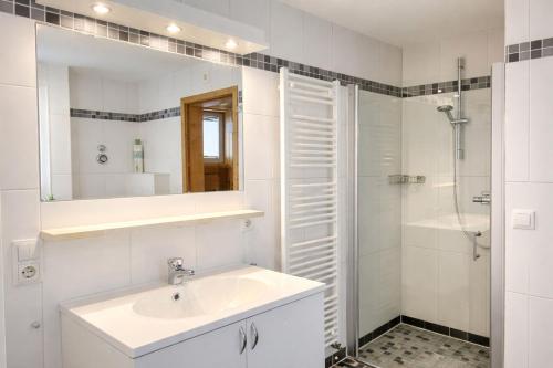 ein weißes Badezimmer mit Waschbecken und Dusche in der Unterkunft Granata in Schillig