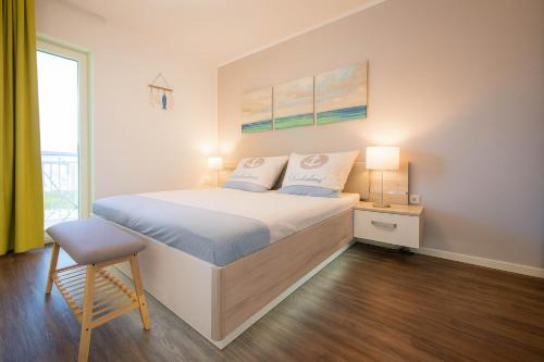 a bedroom with a bed and a chair and a window at Strandnah in Schillig