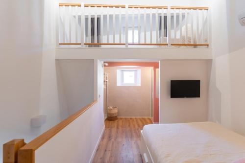 a bedroom with a bed and a television in a room at Lavagnou Duplex in La Ciotat