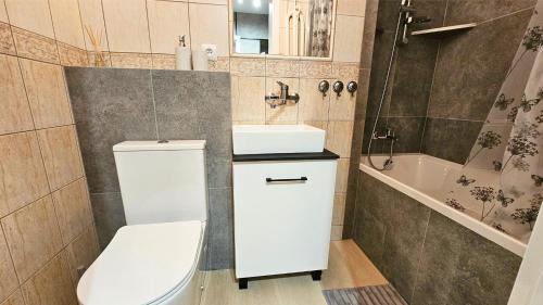 a bathroom with a toilet and a sink and a tub at Piękna 20 Residence in Łomża