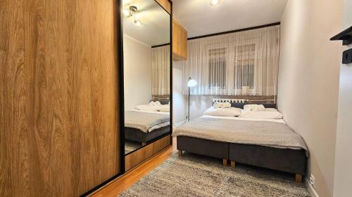 a bedroom with two beds and a mirror at Piękna 20 Residence in Łomża