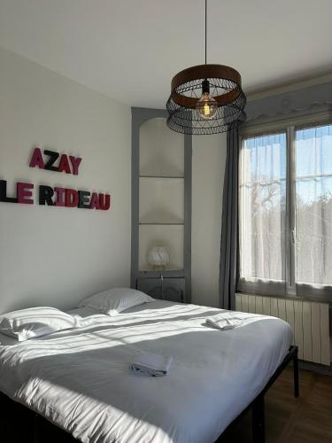 a bedroom with a bed and a sign on the wall at Studio avec vue sur le Château in Azay-le-Rideau